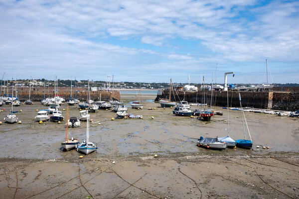 St Aubin, Jersey: 07 August 2025: St Aubin's Harbour at low tide with boats lying on the sand