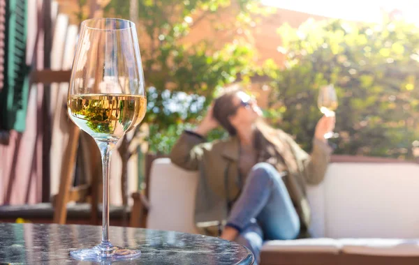 Copo de vinho branco gelado na mesa sobre a jovem mulher e Toscana backgound — Fotografia de Stock