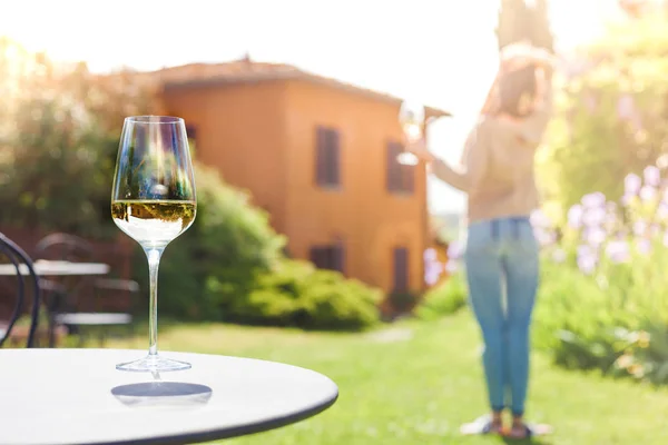 Szklankę schłodzonego białego wina na stole nad młodą kobietę i ochrona Tuscany — Zdjęcie stockowe