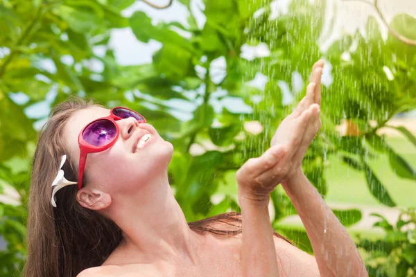 Jovem refrescante no chuveiro tropical — Fotografia de Stock