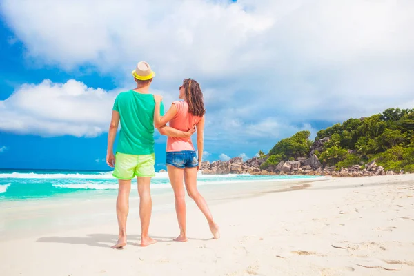 Feliz joven pareja caminando y divirtiéndose por la playa — Foto de Stock