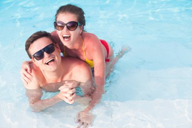 Genç çift rahatlatıcı ve lüks havuzun yanında having fun