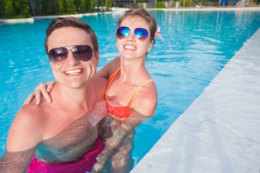 Genç çift rahatlatıcı ve lüks havuzun yanında having fun