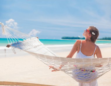 Rahatlatıcı bir hamak beach tarafından beyaz elbiseli Genç kadın