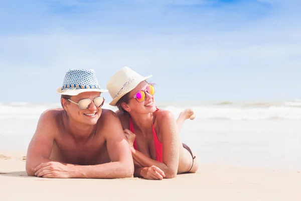 快乐的年轻夫妇说谎和热带海滩上玩乐 — 图库照片