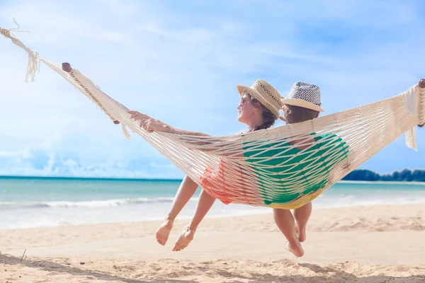 Pareja joven enamorada relajándose en una hamaca junto a la playa —  Fotos de Stock