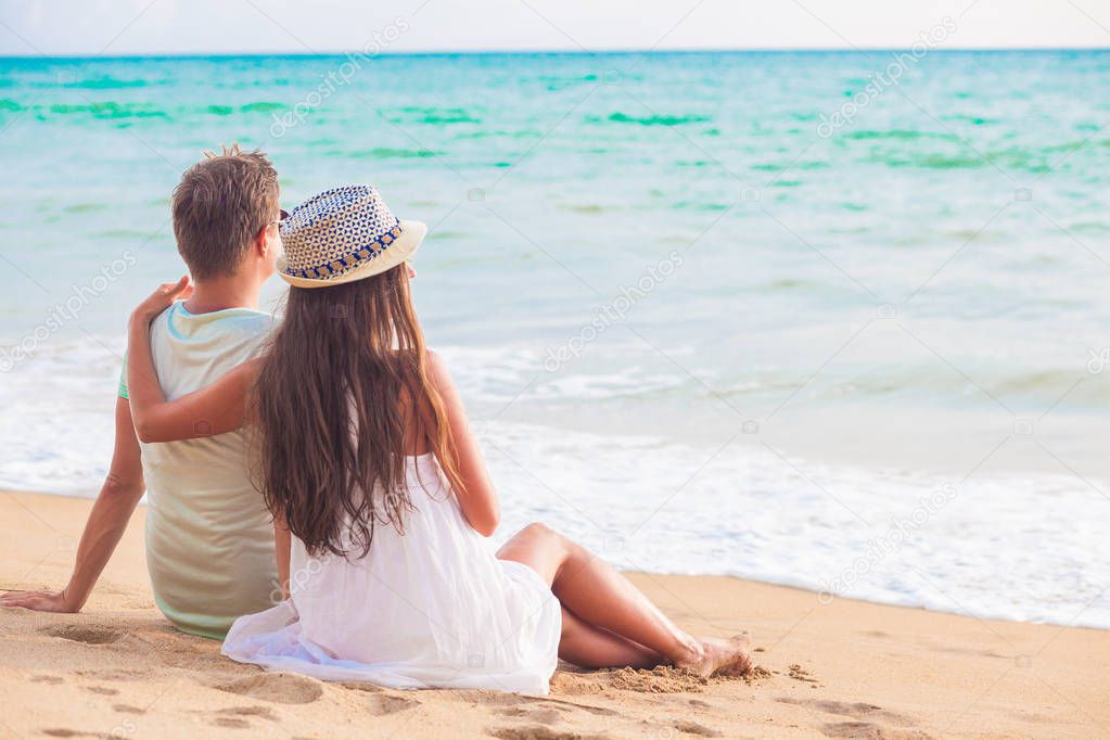 back view of couple sitting on a tropical beach. Khao Lak, Thailand