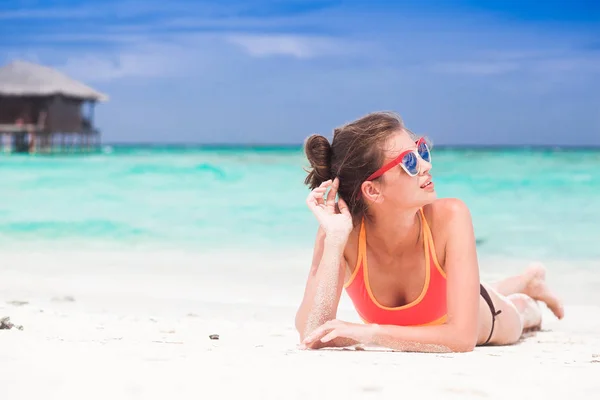 Kobieta w bikini i słomy kapelusz leżącego na tropikalnej plaży — Zdjęcie stockowe