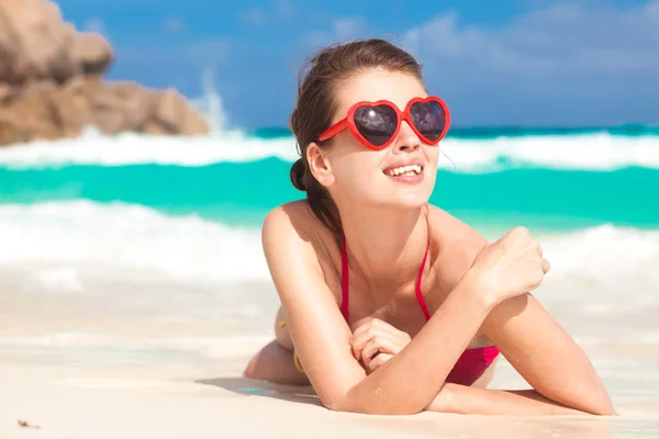 Portret van mooie vrouw in hart vormige zonnebril ontspannen op tropisch strand. La Digue, Seychellen — Stockfoto