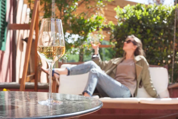 Glas gekühlter Weißwein auf dem Tisch über junger Frau und toskanischem Hintergrund — Stockfoto