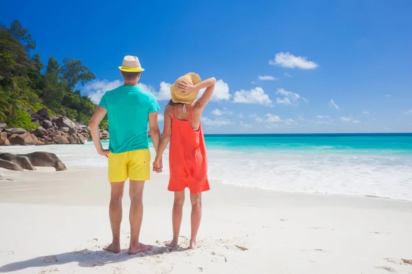 Casal em roupas brilhantes em uma praia tropical em Praslin, Seychelles . — Fotografia de Stock