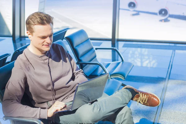 Frau arbeitet mit Laptop am Flughafen und wartet auf ihren Flug — Stockfoto