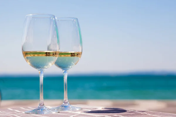 Dvě skleničky z chlazeného bílého vína na stole na pozadí Garla Lake — Stock fotografie