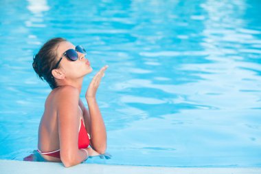 Lüks havuza gülümseyen güneş gözlüğü güzel genç kadın