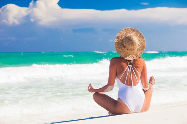 Mladá žena v bikinách a slaměném klobouku relaxačních na bílé karibské pláži — Stock fotografie