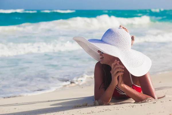 Junge Frau im Bikini und weißem Strohhut entspannt am weißen Karibikstrand — Stockfoto