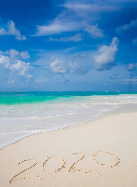Ano Novo 2020 escrito à mão na praia com onda oceânica — Fotografia de Stock