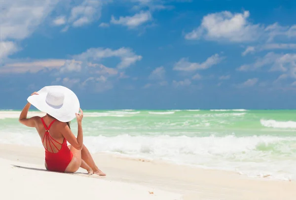 Young woman in bikini and white straw hat relaxing at white caribbean beach — Stock Photo, Image
