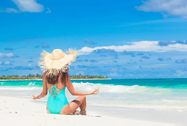 Jonge vrouw in bikini en stro hoed ontspannen op witte Caribische strand — Stockfoto