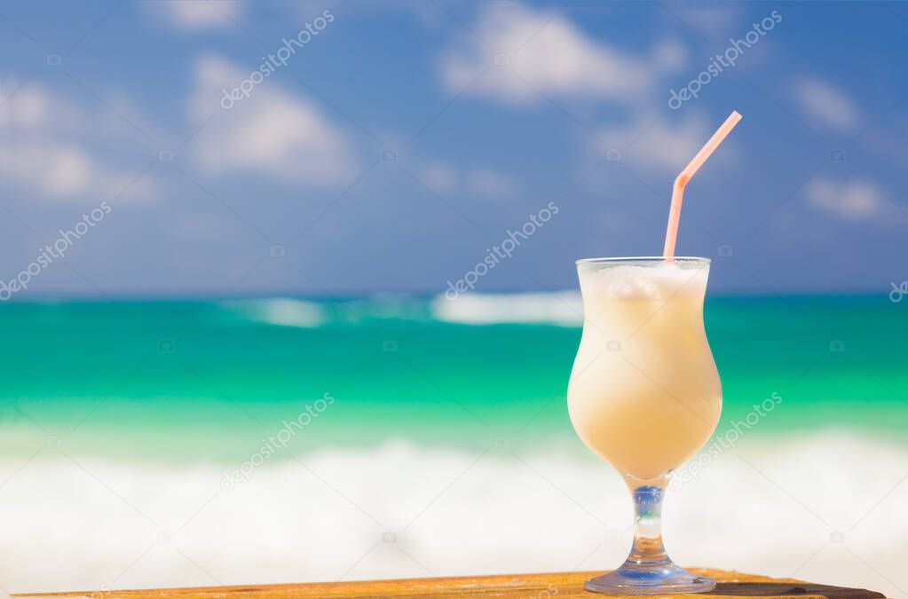 picture of pina colada and sunglasses on tropical beach
