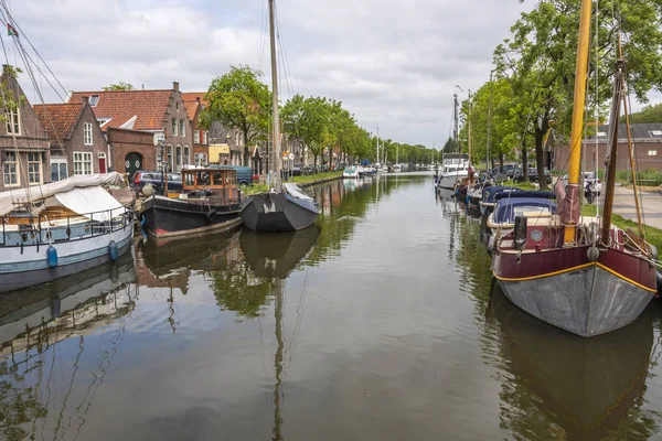 canal and boats with houses on the sides of them in the city of edam. netherlands