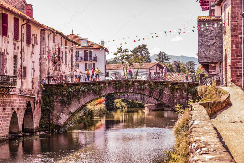 Main bridge over the river Nive on its way through the village of Saint Jean Pied de Port and in the background the Pyrenees. France.