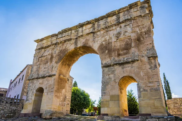 Close-up of a Roman arch from the time of the Emperor Trajan, the only one remaining from three spans in Spanish territory and the town of Medinaceli behind. Soria Spain