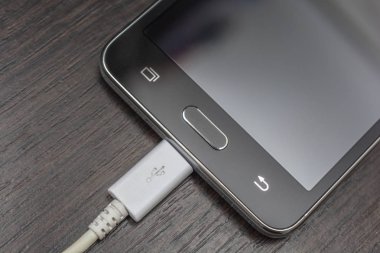 Hareket eden smartphones ahşap bir masa üzerinde beyaz bir tel şarj