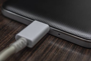 Hareket eden smartphones ahşap bir masa üzerinde beyaz bir tel şarj
