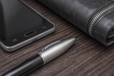 bir kalem ve çanta yalan bir ahşap masa arka plan üzerine telefonla