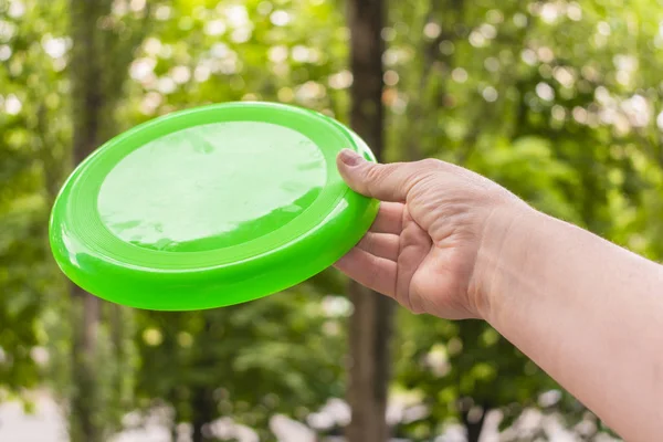 bir yaz günü parkta yeşil bir frizbi disk atma el