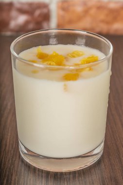 Portakal Reçeli ve rustik ahşap bir masa üzerinde bir tuğla duvar arka plan cam bardakta dilimleri ile yoğurt