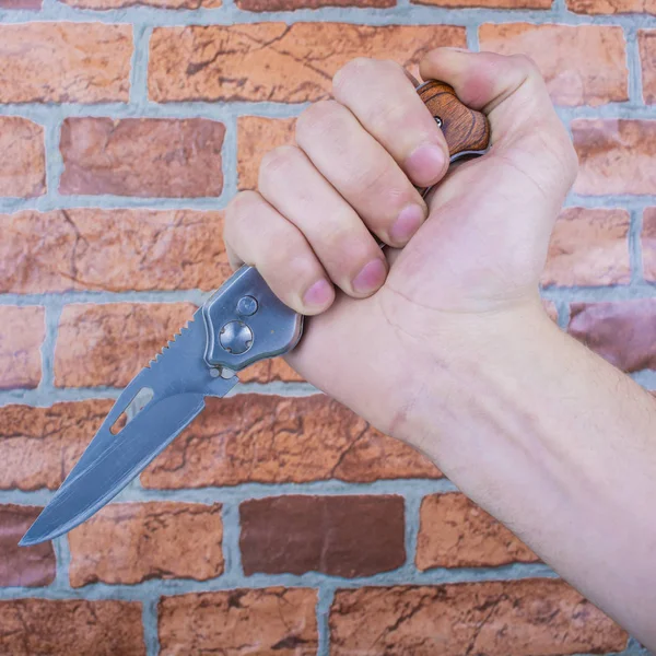 Składany Nóż Ręce Mężczyzn Tle Ściany Cegieł Pomarańczowy — Zdjęcie stockowe