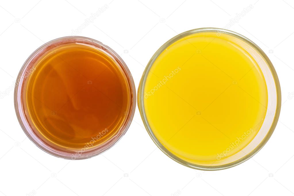 Two clear glass glasses of fresh orange and apple juice isolate on white background