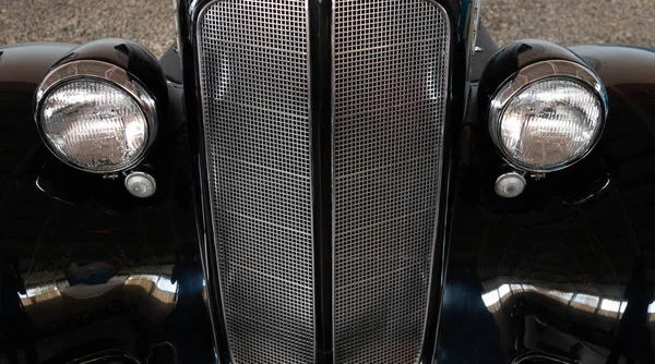 Vintage, black, shiny, chrome car. Radiator and headlights.