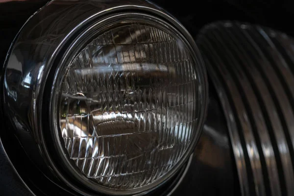 The headlight of an antique, rarity, vintage black car.