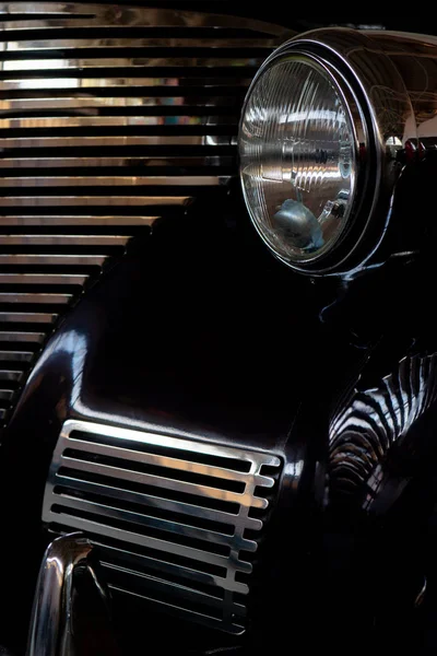 The headlight of an antique, rarity, vintage black car.