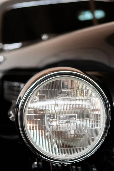 The headlight of an antique, rarity, vintage black car.