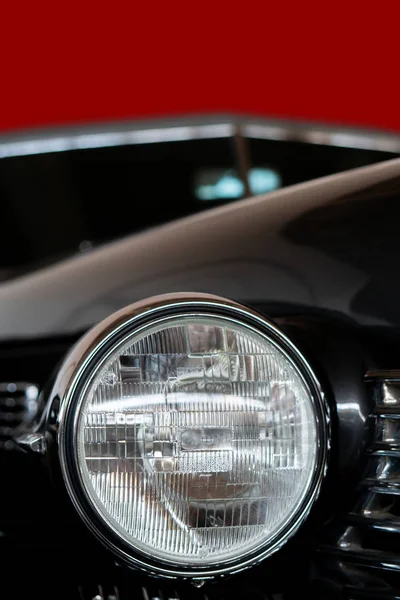 The headlight of an antique, rarity, vintage black car.