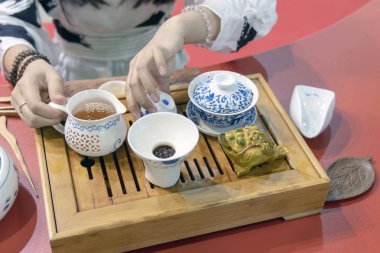 Çin çay töreni. Kız çaydanlığı ocağa çay fincan içine dökülen..