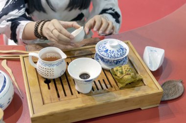 Çin çay töreni. Kız çaydanlığı ocağa çay fincan içine dökülen..