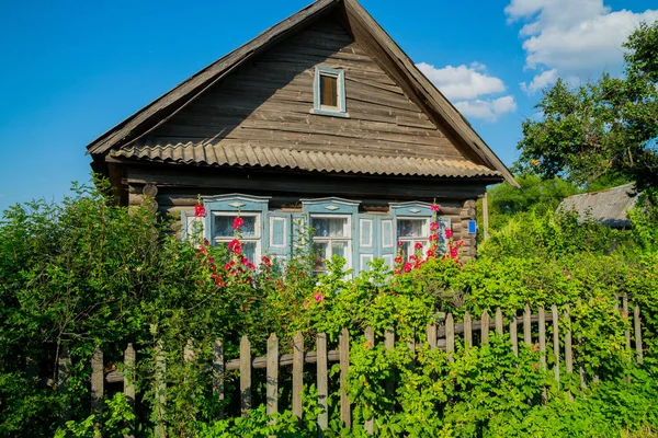 Červené Květy Před Okny Starého Dřevěného Domu — Stock fotografie