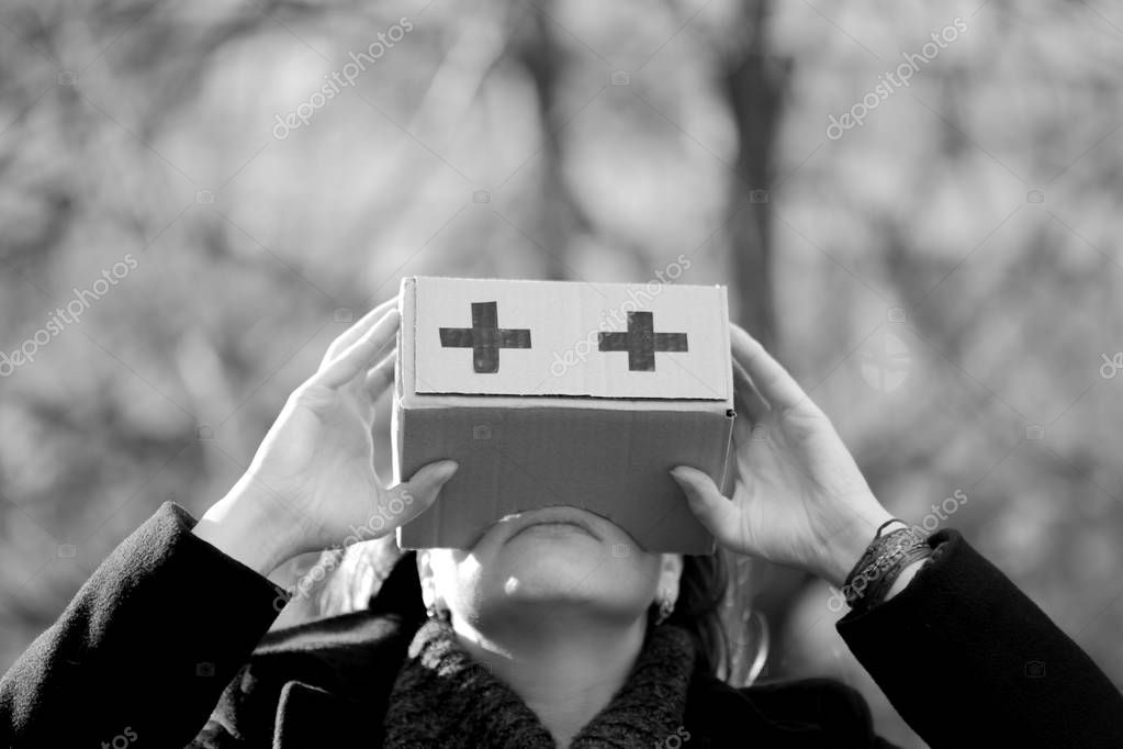 A man is holding a box near his eyes