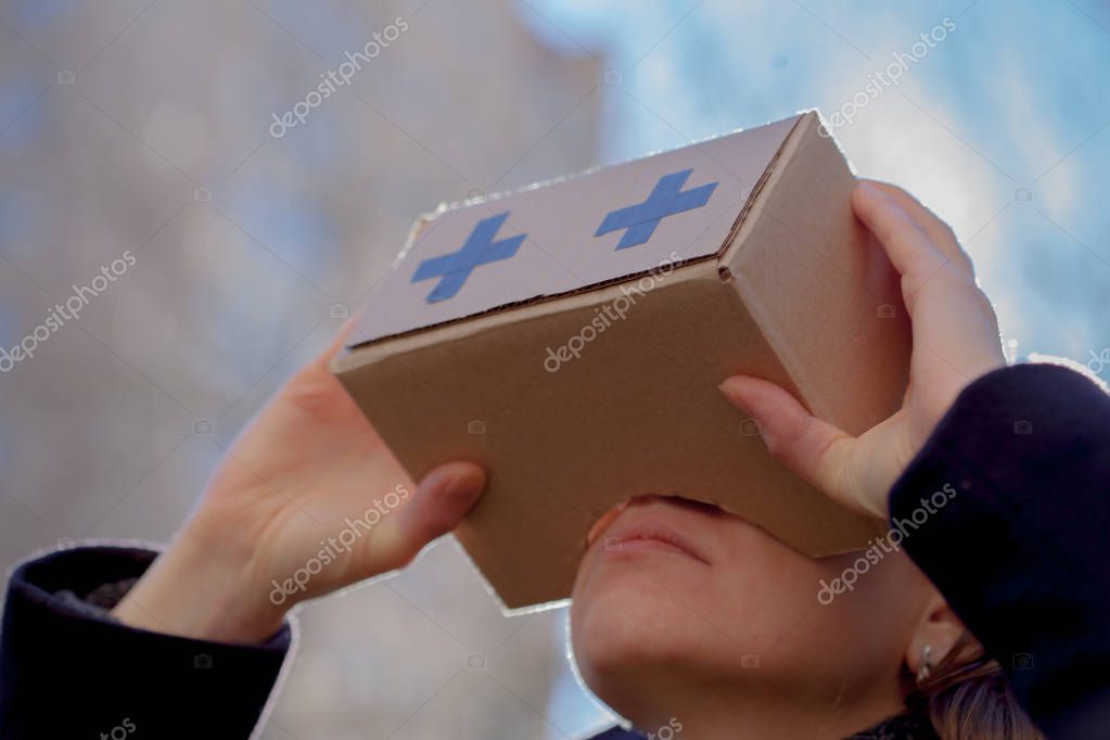 A man is holding a box near his eyes