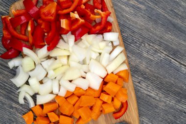Mutfakta yemek. Kesilmiş soğan, havuç, tatlı Bulgar biber.