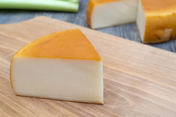 Piece of farm cheese on wooden board