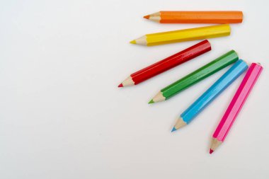 Beyaz arkaplanda renkli kalemler.