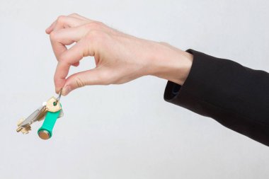 Erkek el iki parmak ile anahtarları tutan, closeup atış