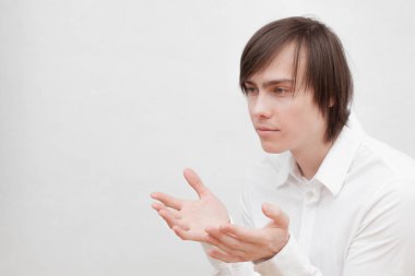 Gri stüdyo arka planda poz, şık giysiler içinde genç adam portresi 