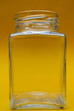 Sarı arka plan üzerinde boş kare cam kavanoz